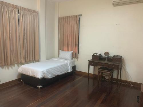 a small bedroom with a bed and a desk at Tanwa Suite - MRT Ratchadapisek in Bangkok