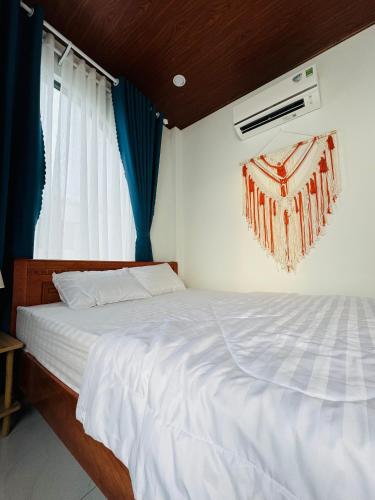 a bedroom with a white bed with blue curtains at Vile Villa Homestay View Biển 01 Đảo Phú Quý in Cu Lao Thu