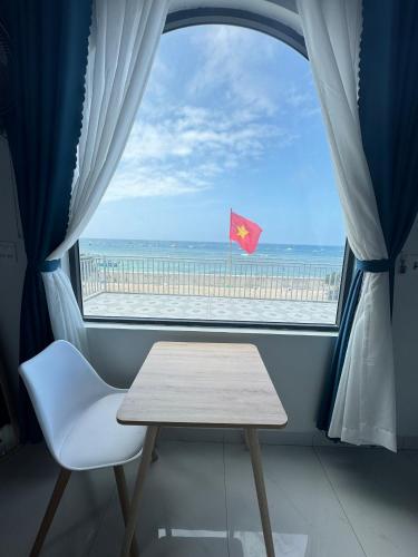 a window with a table and a view of the beach at Vile Villa Homestay View Biển 01 Đảo Phú Quý in Cu Lao Thu