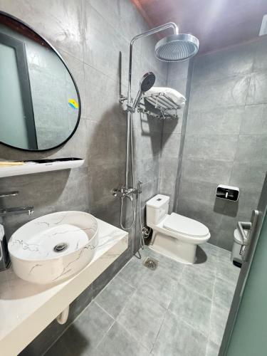 a bathroom with a toilet and a sink and a mirror at Vile Villa Homestay View Biển 01 Đảo Phú Quý in Cu Lao Thu
