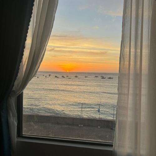 a view of the ocean from a window with a sunset at Vile Villa Homestay View Biển 01 Đảo Phú Quý in Cu Lao Thu
