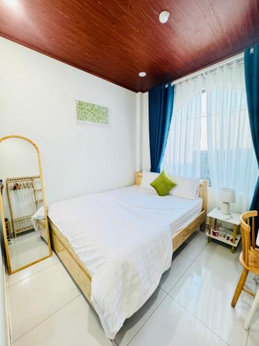 a bedroom with a bed with a mirror and blue curtains at Vile Villa Homestay View Biển 01 Đảo Phú Quý in Cu Lao Thu