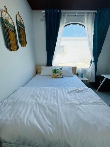 a large bed in a room with a window at Vile Villa Homestay View Biển 01 Đảo Phú Quý in Cu Lao Thu