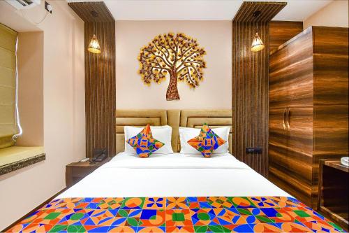 1 dormitorio con 1 cama con un árbol en la pared en FabHotel Prime Jalsa, en Calcuta