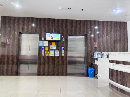 a lobby with two elevators and a television at Jeamco Royal Hotel-Palawan in Puerto Princesa City
