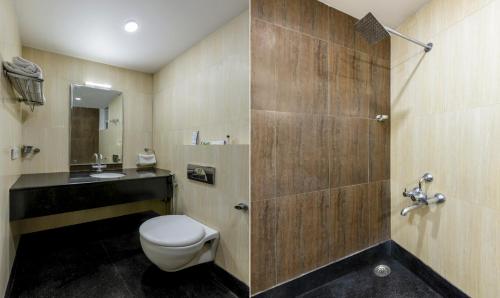 a bathroom with a toilet and a sink at Hiland suites in Bangalore
