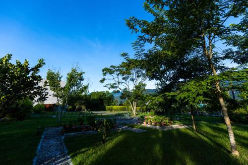 a park with a bench and trees and grass at Penlai Home in Fengli