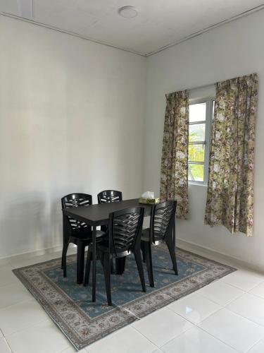 a dining room with a black table and chairs at Cantik-La Homestay 3 Bilik Kuala Terengganu in Bukit Payong