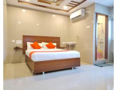 1 dormitorio con 1 cama con almohadas de color naranja en Hotel Grand Inn, Warangal, en Warangal