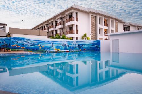 a swimming pool in front of a building at Palm Regal Resort in Gopālpur