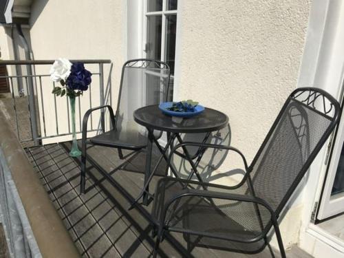 d'une table et de deux chaises sur un balcon. dans l'établissement Windrose FV 6_c_o_ ruegenlotse, à Binz