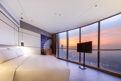 a hotel room with a bed and a large window at Atour Hotel Zhongshan Ancient Town Huayi Plaza in Zhongshan