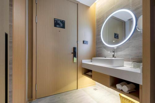 a bathroom with a sink and a mirror at Atour Hotel Ningbo Zhenhai New City in Ningbo