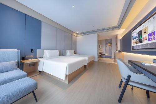 a hotel room with a bed and a desk and chairs at Atour X Hotel Nanjing Jiangning Future Internet Town in Jiangning