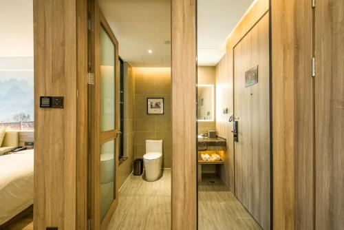 a bathroom with a toilet and a sink in a room at Atour Hotel Foshan Nanhai Qiandeng Lake Guicheng in Nanhai