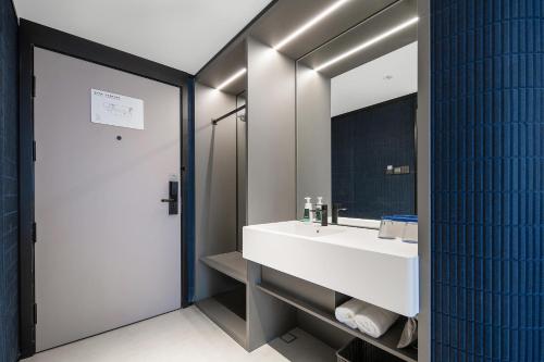 a bathroom with a white sink and a mirror at Atour Light Hotel Chengdu Shuangliu Airport Jinhua Road in Chengdu
