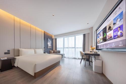 武漢市にあるAtour Hotel Wuhan Chuhe Han Street Hongshan Plazaのベッド1台、薄型テレビが備わるホテルルームです。