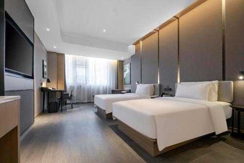 a hotel room with two beds and a desk at Atour Hotel Ningbo Zhenhai New City in Ningbo