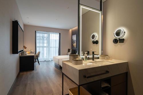 a bathroom with a sink and a large mirror at Atour Hotel Chengdu Xibo City Shuzhou Road in Chengdu