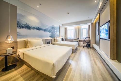 a hotel room with two beds and a desk at Atour Hotel Shengtai West Road South Railway Station Nanjing in Nanjing