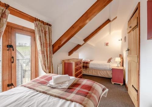 - une chambre avec 2 lits et une fenêtre dans l'établissement Beacons View Farm Cottages, à Merthyr Cynog