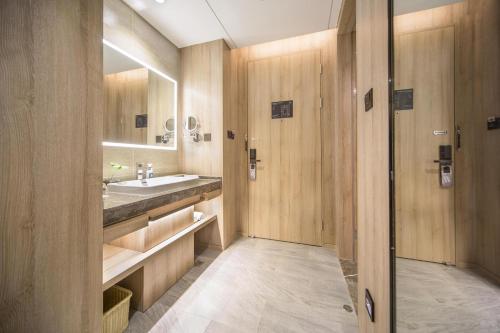 La salle de bains est pourvue d'un lavabo et d'un miroir. dans l'établissement Atour Hotel Shengtai West Road South Railway Station Nanjing, à Nankin