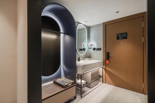 La salle de bains est pourvue d'un lavabo et d'un miroir. dans l'établissement Atour Hotel Chengdu East Jiuyanqiao Street, à Chengdu