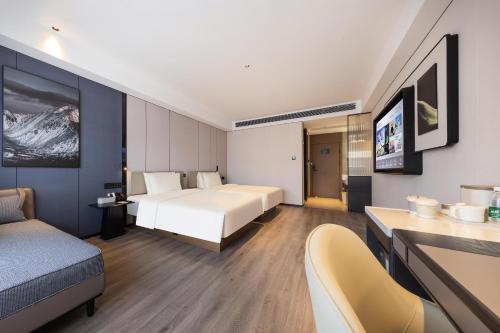 a hotel room with a bed and a couch at Atour Hotel Guangzhou Baiyun Jiahe Hebian in Guangzhou