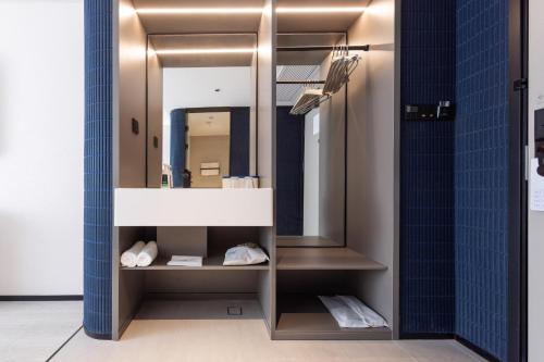 a bathroom with a mirror and blue tiles at Atour Light Hotel Shenzhen North Station Hongshan Metro Station in Lung Wa