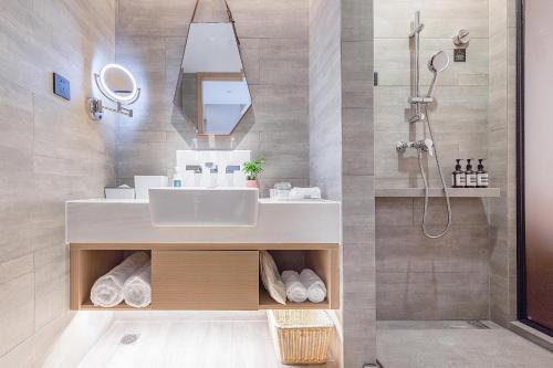 a bathroom with a sink and a shower at Atour Hotel Ningbo Yinzhou Wanda Mingzhouli in Ningbo
