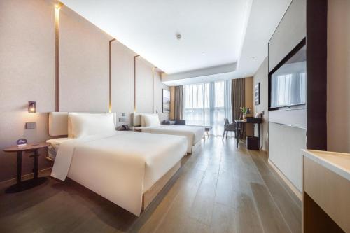 a hotel room with two beds and a table at Atour Hotel Nanjing Software Avenue Metro Station in Nanjing
