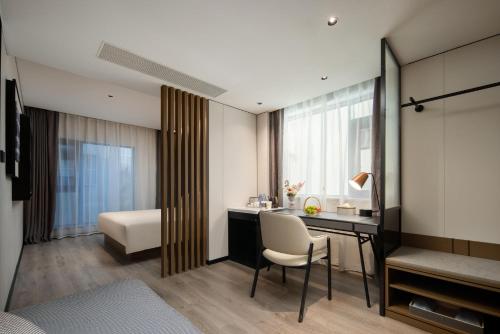 a hotel room with a desk and a bed and a bedroom at Atour Hotel Sanya Bay Fenghuang Road in Sanya
