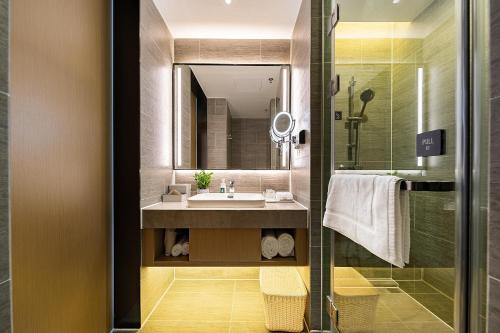 a bathroom with a sink and a mirror at Atour Hotel Zhongshan Ancient Town Huayi Plaza in Zhongshan