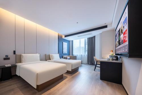a hotel room with a bed and a flat screen tv at Atour Hotel Sanya Government Affairs Center Hedong Road in Sanya