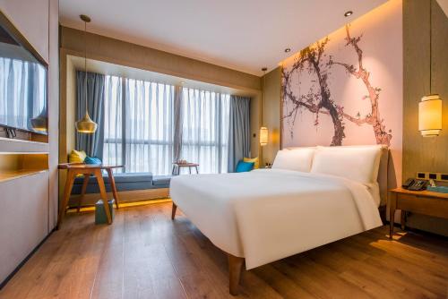 um quarto com uma grande cama branca e uma janela em Atour S Hotel Guangzhou Beijing Road Tianzi Wharf em Guangzhou