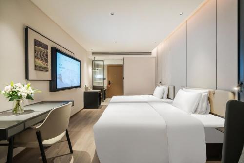 a hotel room with two beds and a desk at Atour Hotel Chengdu East Jiuyanqiao Street in Chengdu