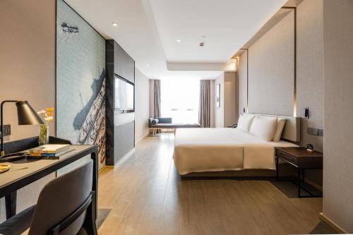 a hotel room with a bed and a desk at Atour Hotel Ningbo Bund Road Jinxintiandi in Ningbo