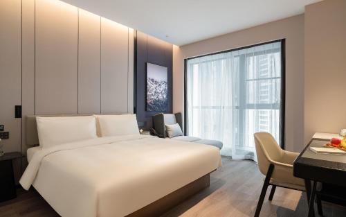 1 dormitorio con 1 cama blanca grande y escritorio en Atour Hotel Chengdu Xibo City Shuzhou Road en Chengdú