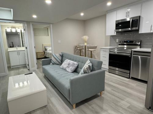a living room with a couch and a kitchen at Brand new 2 Bedrooms modern guest suite with separate entrance in Calgary