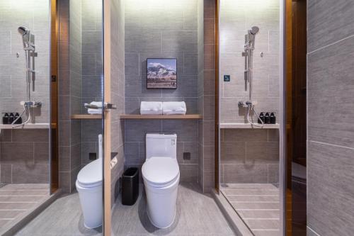 a bathroom with a toilet and two sinks and a shower at Atour Hotel Nanjing Software Avenue Metro Station in Nanjing