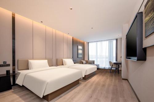 a hotel room with two beds and a television at Atour Hotel Nanjing Medical Valley Xinghuo Road in Nanjing