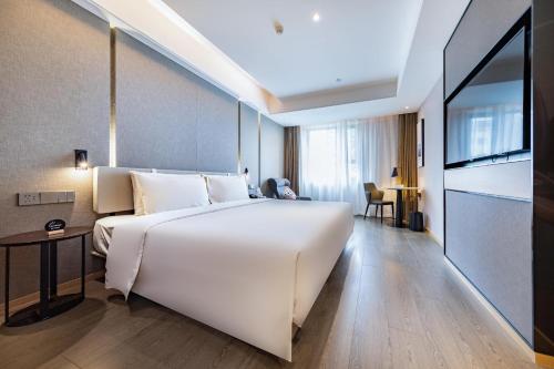 a large white bed in a hotel room at Atour Light Hotel Zhuhai Lovers Road Grand Theater in Zhuhai