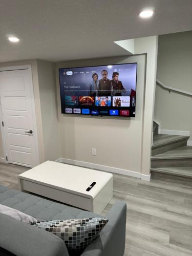 a living room with a flat screen tv on the wall at Brand new 2 Bedrooms modern guest suite with separate entrance in Calgary