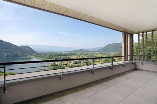 a balcony with a view of a river and mountains at Bella Vista Seeblick in Annenheim
