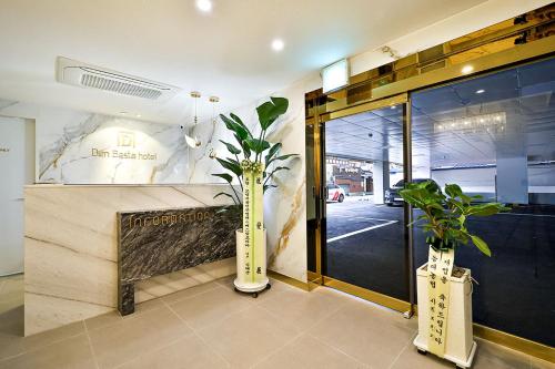 a lobby with two vases with plants in it at Denbasta Hotel Daeyeon in Busan