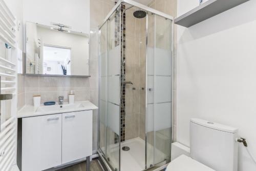 een badkamer met een douche, een wastafel en een toilet bij Appartement au calme et proche des transports in Créteil
