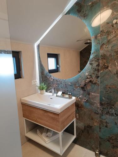 a bathroom with a sink and a mirror at My Little Village in Poiana Mărului