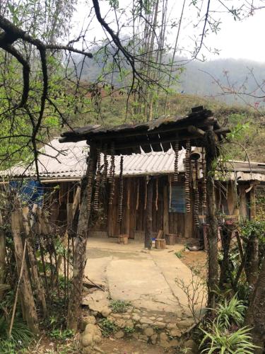uma casa velha com um telhado na floresta em `Sin Chai Homestay em Sapa