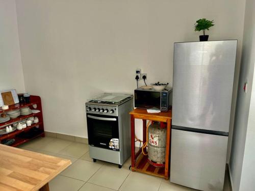 a kitchen with a stainless steel refrigerator and a stove at A Home Away from Home. in Fumba