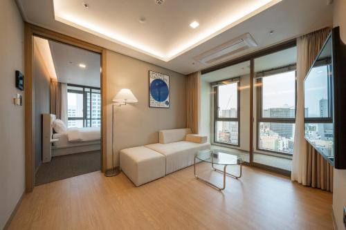 釜山的住宿－Soyou By Haeundae，客厅配有白色沙发和大窗户